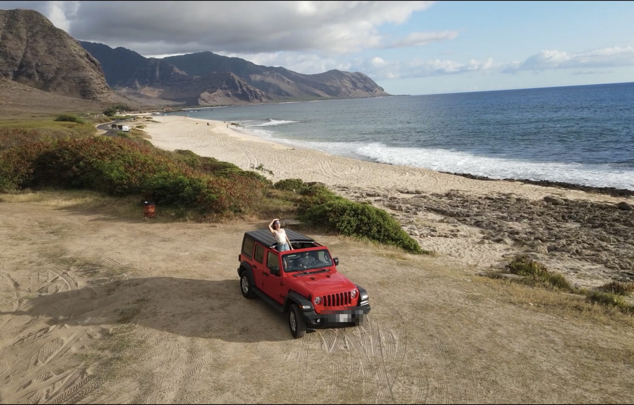 Aerial of red 4x4 on a Hawaiian coastline