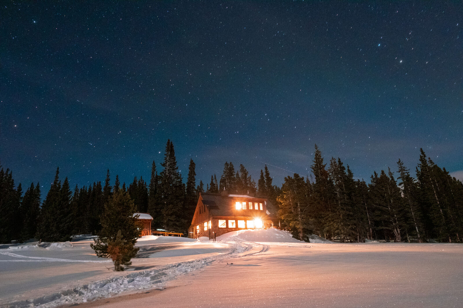 Backcountry lodge glowing under a starry sky