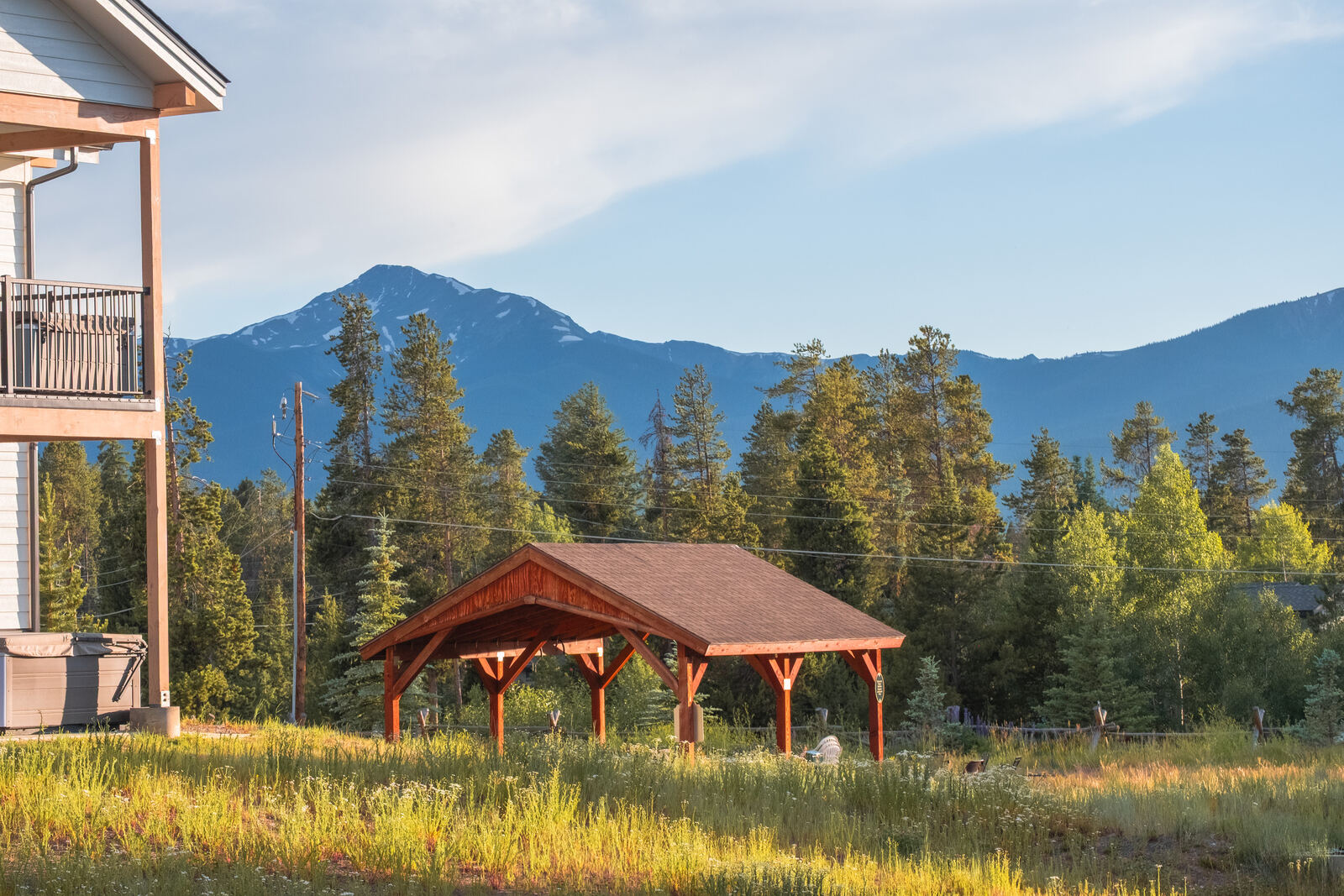 Timber pavilion with mountain backdrop at golden hour